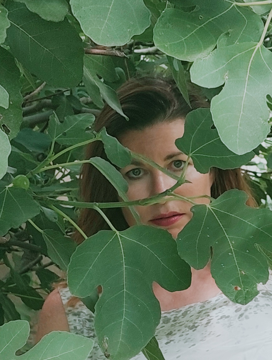 Portrait of a woman framed by green leaves